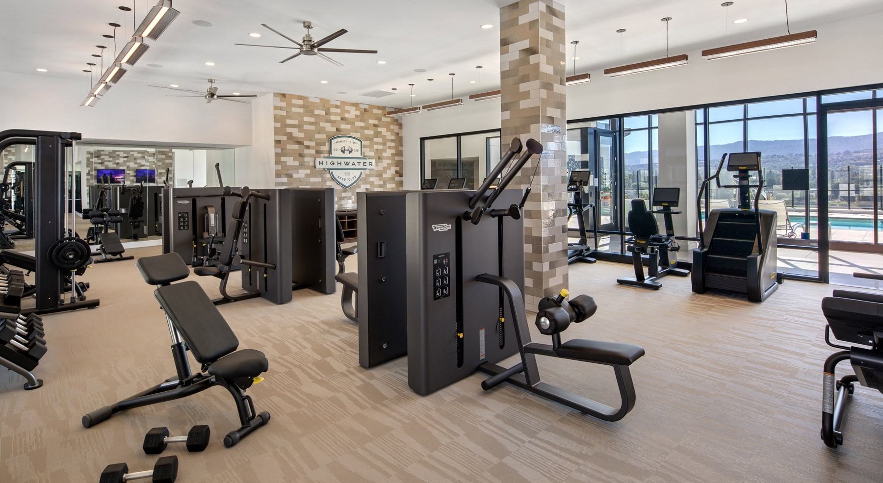 Open and well-lit fitness center with plenty of cardio and strength training equipment